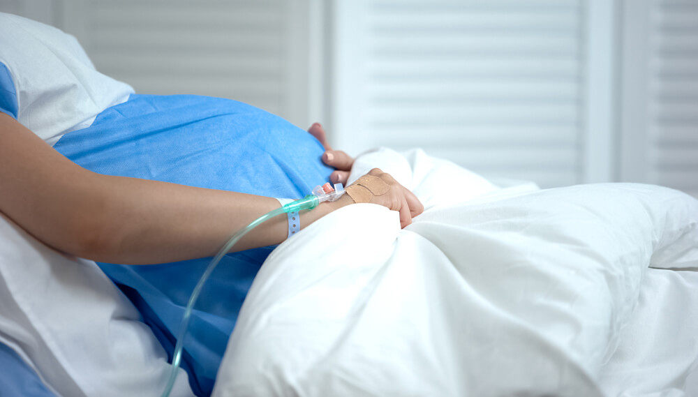 Pregnant woman lying on hospital bed.